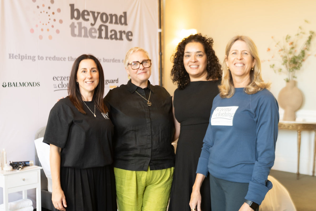 4 specialist brand team members stand before an event banner for Beyond The Flare - an event bringing together lived experience to discuss the effects and management of eczema symptoms beyond the flare
