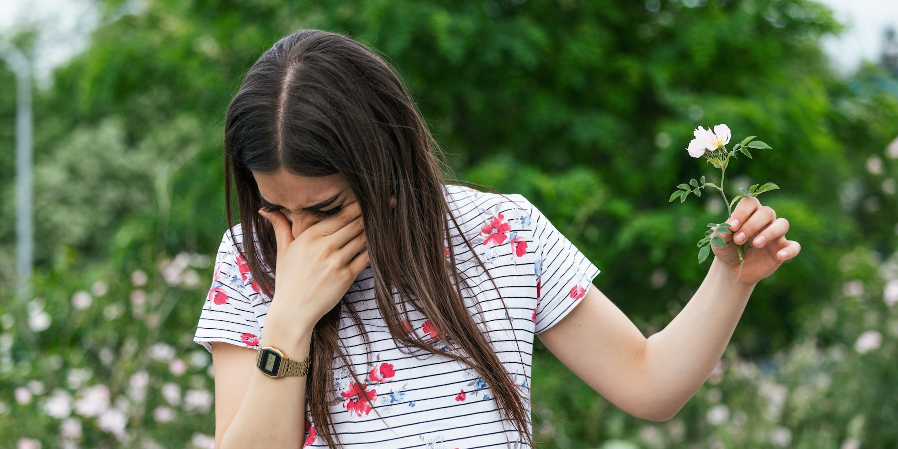 Balmonds Hayfever Hacks - woman holding a flower and sneezing