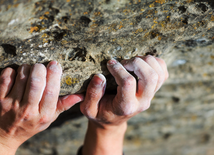 A climbers hands gripping on to rock