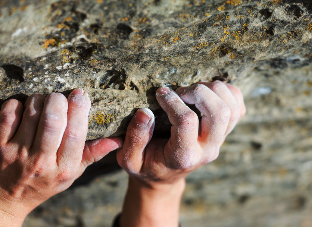 A climbers hands gripping on to rock